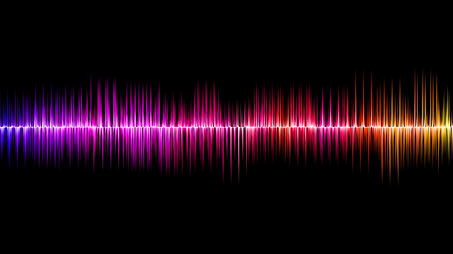 Colourful sound wave on black background, in purple, pink, orange, and yellow