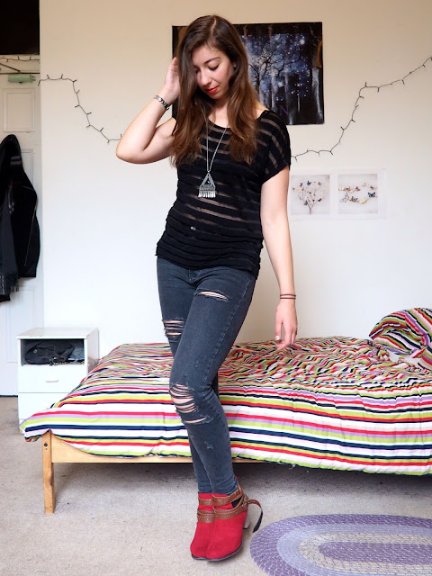 Ruby Red - outfit of black sheer striped top, grey ripped skinny jeans, and red high heeled ankle boots with brown straps