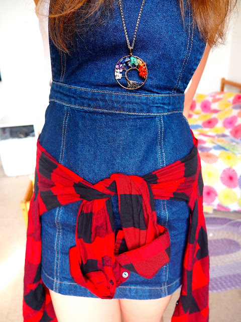 Spring Sunshine - outfit of denim dungaree dress, white top, red & black flannel checked shirt around the waist, and rainbow tree of life pendant necklace