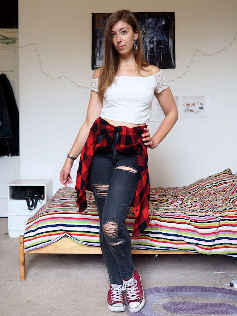 Rematch - outfit of white lace crop top, grey ripped skinny jeans, red & black checked shirt around waist, & red Converse shoes