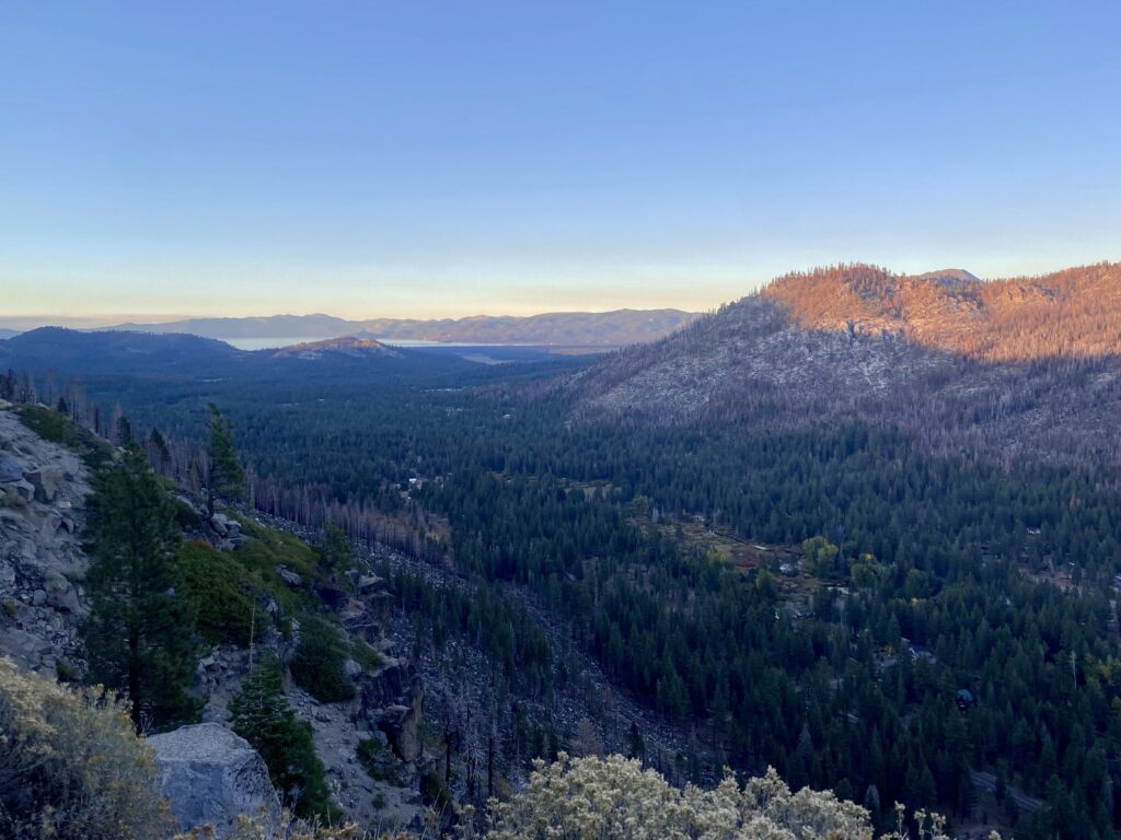 Weekend Trip to Lake Tahoe - second feature photo - mountains and forests at sunset from a roadside viewpoint, with the lake visible in the background