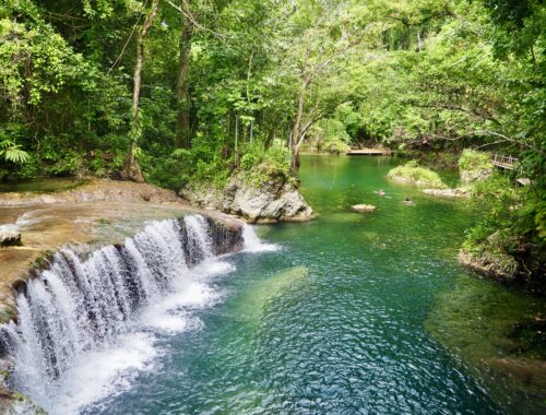 A Week in Vanuatu - feature photo - low waterfall cascade into a turquoise river surrounded by jungle