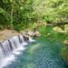 A Week in Vanuatu - feature photo - low waterfall cascade into a turquoise river surrounded by jungle