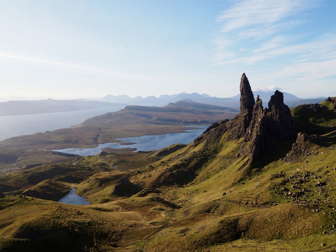 First Trip to the Isle of Skye - feature photo - Old Man of Storr rock formation with loch in the background in the early morning sun - Skye, Scotland