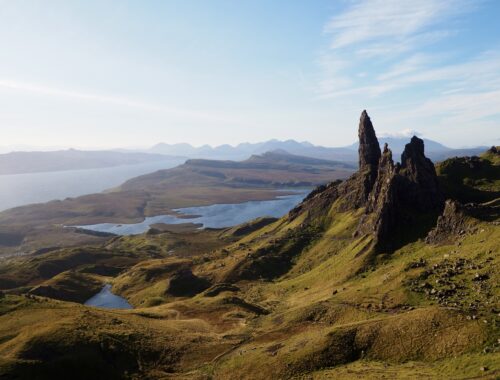 First Trip to the Isle of Skye - feature photo - Old Man of Storr rock formation with loch in the background in the early morning sun - Skye, Scotland